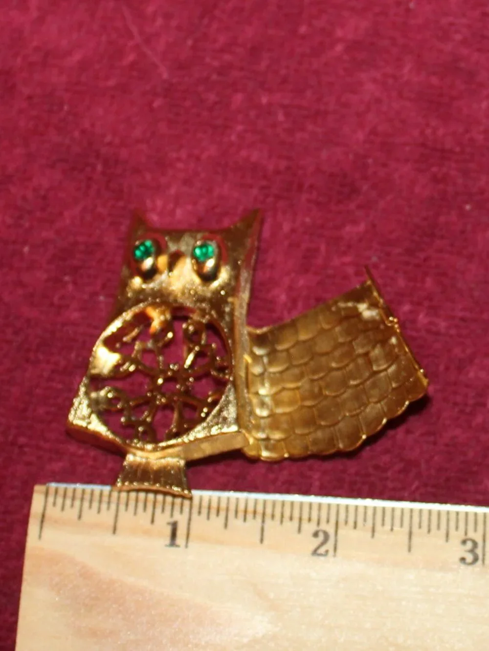 Vintage Avon gold-tone owl brooch with green rhinestone eyes, often featuring a